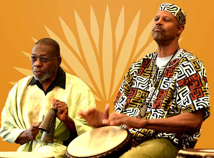 Two African musicians drumming on Djembes against a bright golden background. They wear traditional attire.