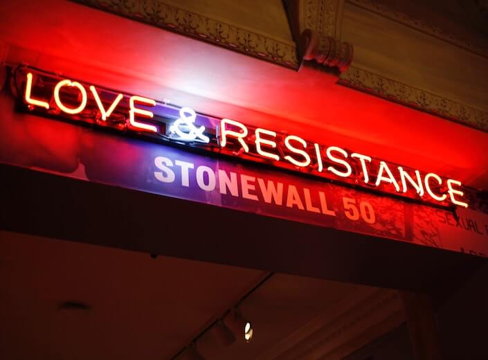 Stonewall - a neon sign that reads "Love and Resistance" is displayed.