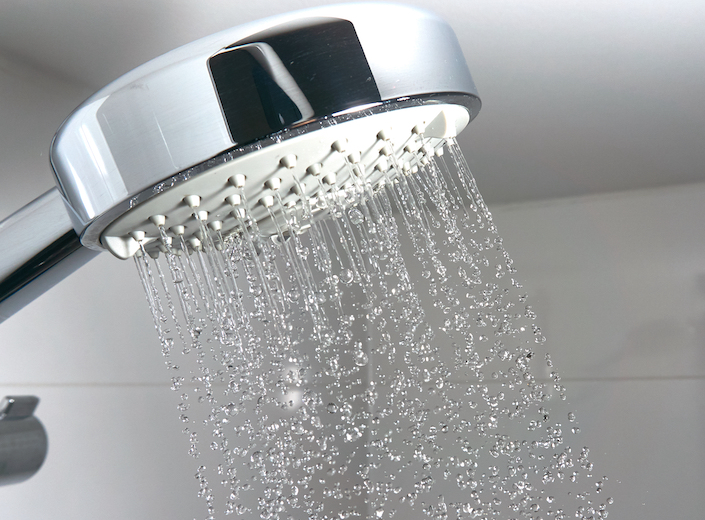 Shower head with water flowing out of it.