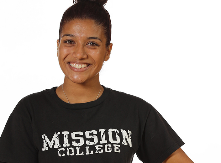 Young woman with a black Mission College t-shirt poses against a white background.